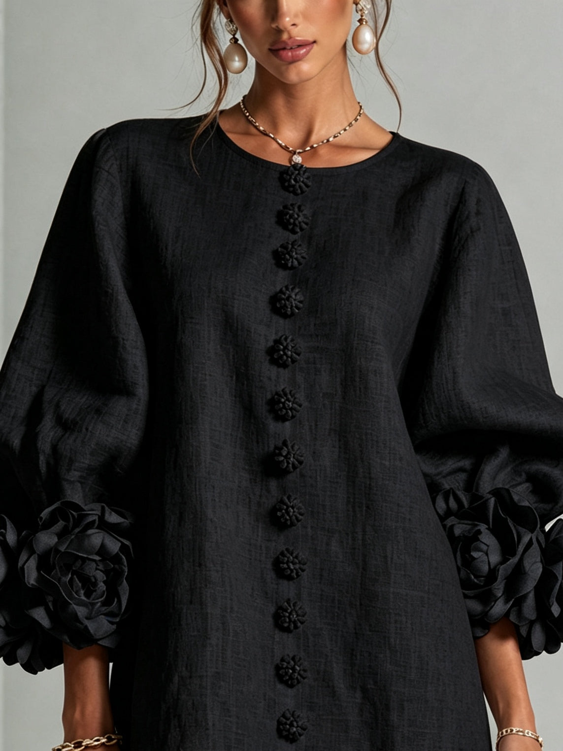 Black midi dress close-up with floral button placket and puff sleeves