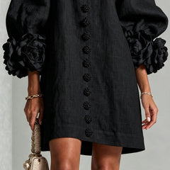Black button-front midi dress hem view with floral front detail and rosette puff cuffs