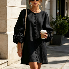 Black button-front midi dress with floral placket, long puff sleeves and rosette cuffs