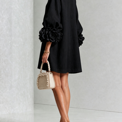 Black button-front midi dress with rosette cuff detail, side angle