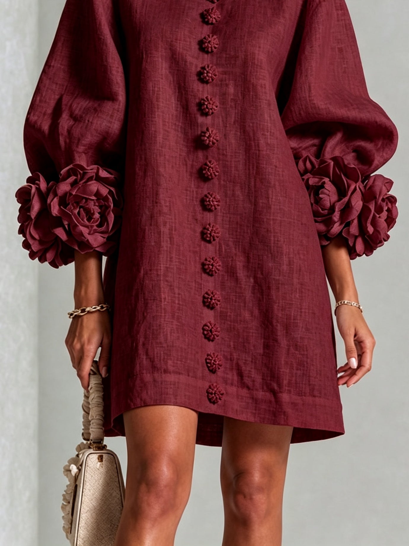 Burgundy linen midi dress close-up with rosette sleeve cuffs and embroidered button placket