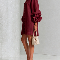 Burgundy midi dress with long puff sleeves and rosette cuff details; side view