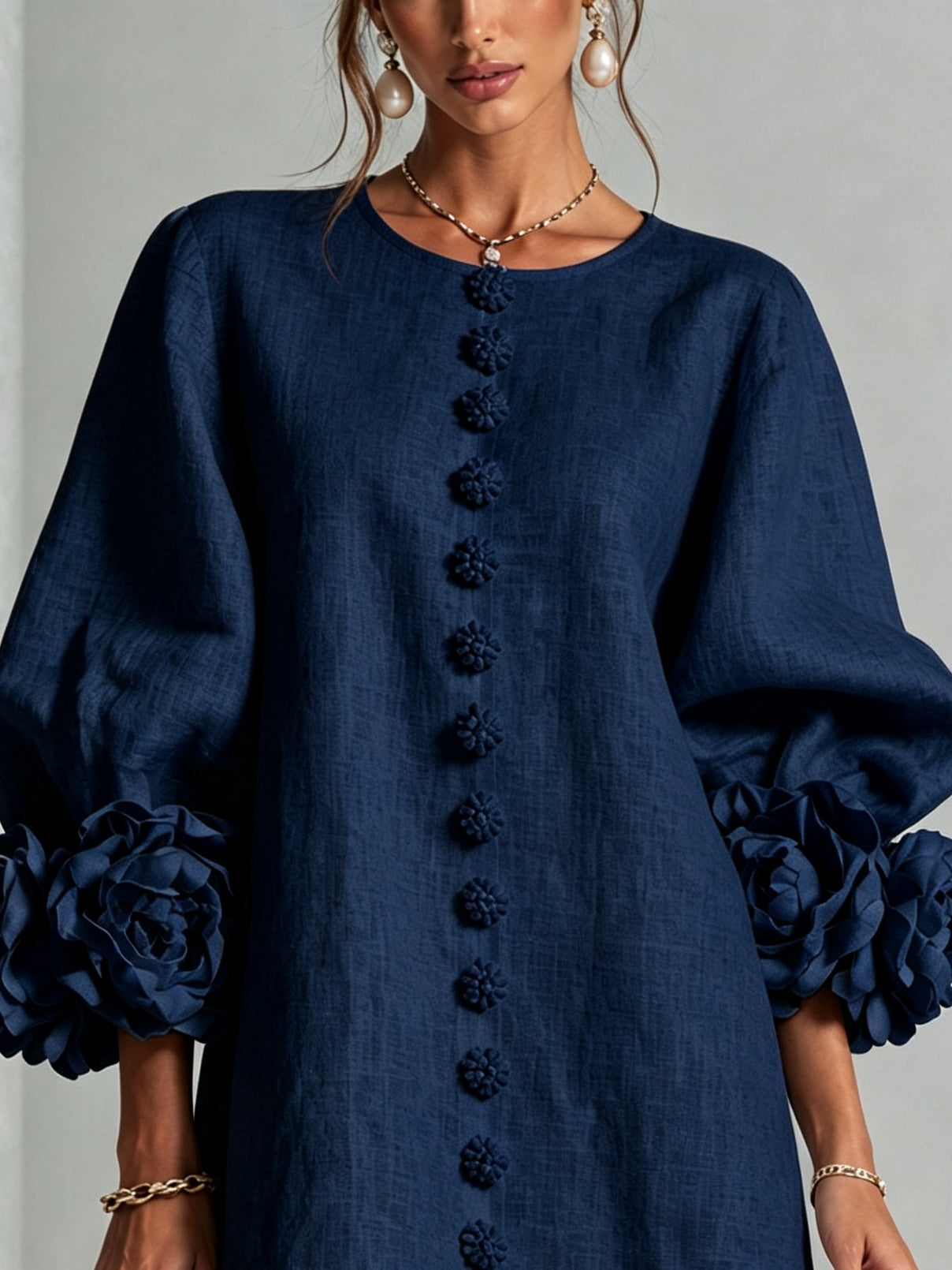 Navy embroidered midi dress close-up showing button trim down the front and puff sleeves