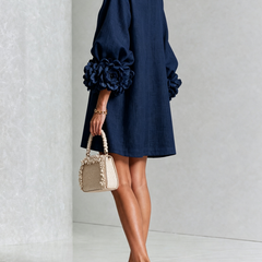Navy embroidered midi dress, angled view with puff sleeves and rose rosette cuff details