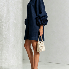 Navy embroidered midi dress, side view with puff sleeves and rosette cuff details