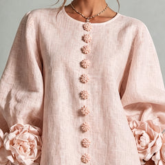 Light pink midi dress close-up: button-front with floral rosette trim