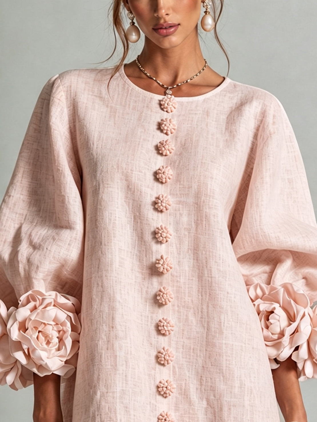 Light pink midi dress close-up: button-front with floral rosette trim