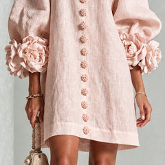 Light pink midi dress with button-front floral rosette detail and puff sleeve cuffs
