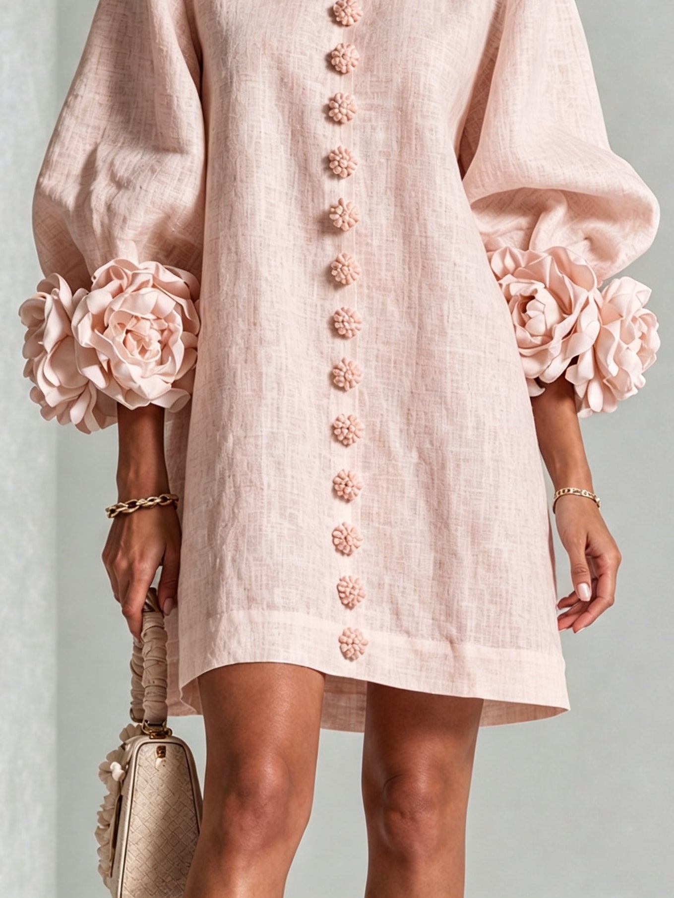 Light pink midi dress with button-front floral rosette detail and puff sleeve cuffs