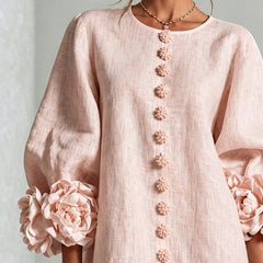 Light pink midi dress close-up: vertical floral rosette button detail