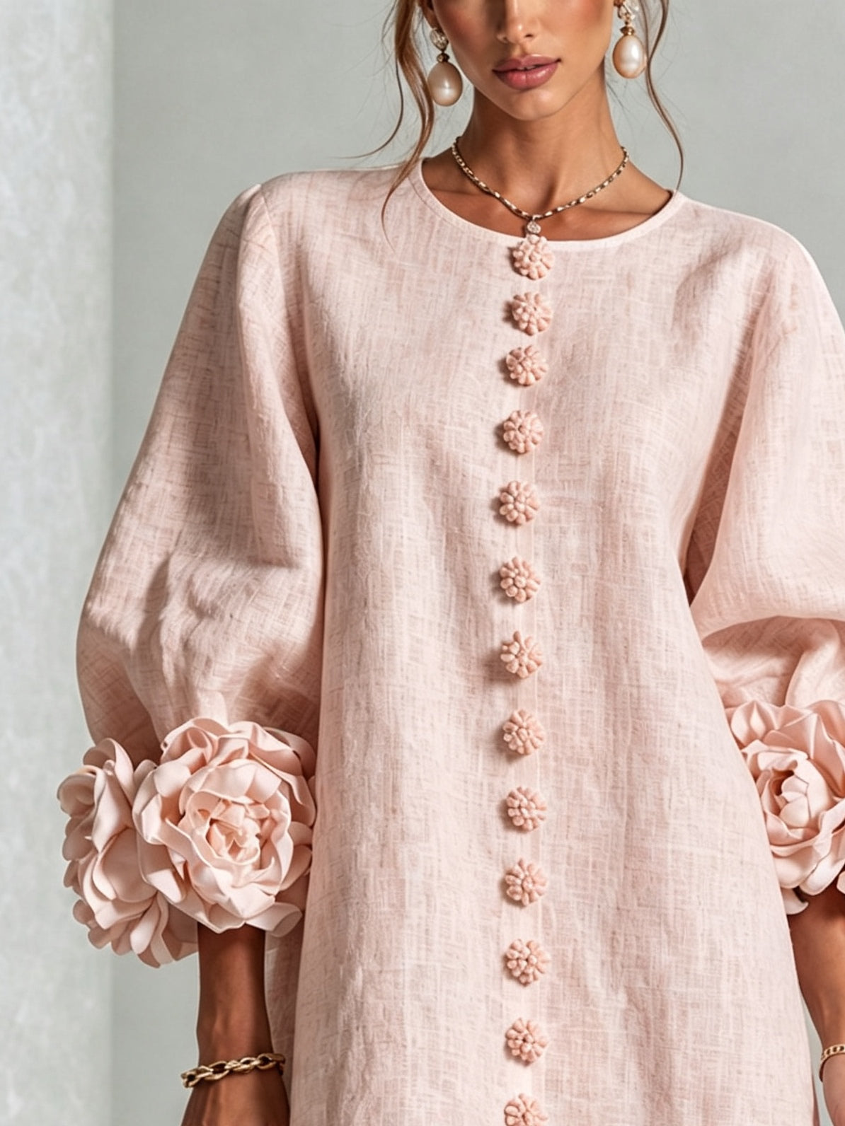 Light pink midi dress close-up: vertical floral rosette button detail