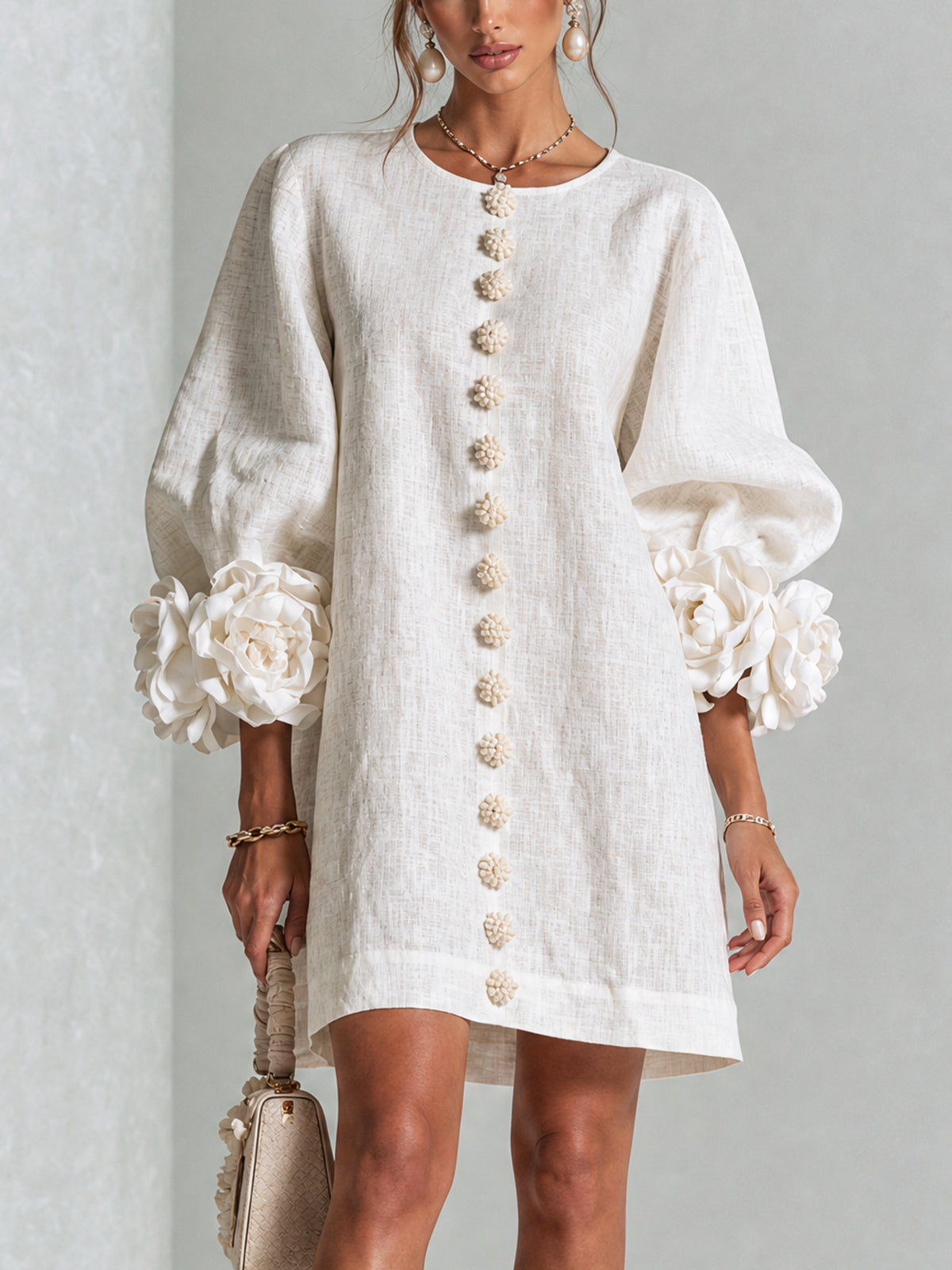 White button-front midi dress with round neckline and puff sleeves with rosette cuffs