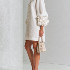 White button-front midi dress, side view, round neck and puff sleeves with rosette cuffs