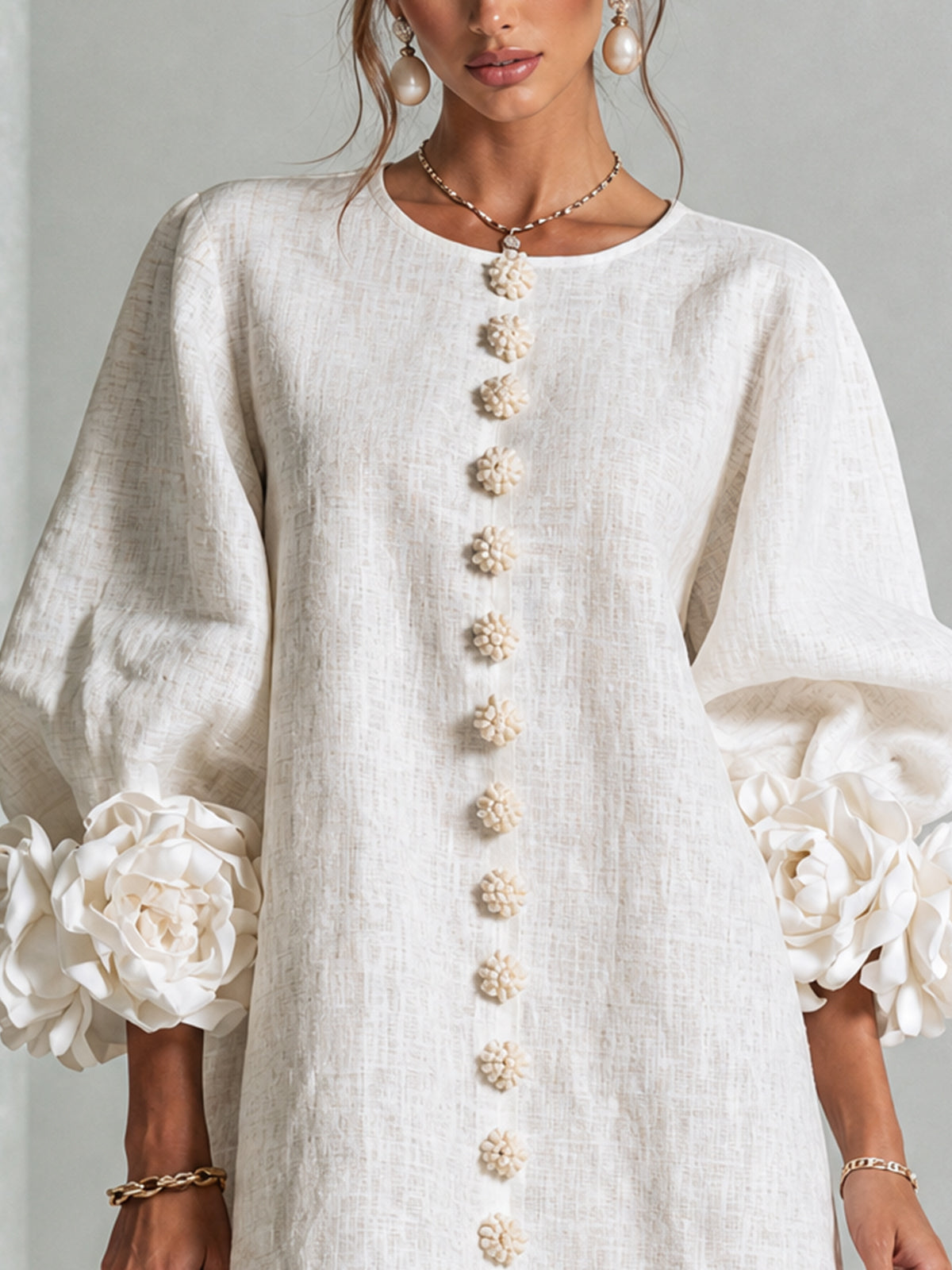 White button-front midi dress close-up, gold decorative buttons and rosette puff sleeves
