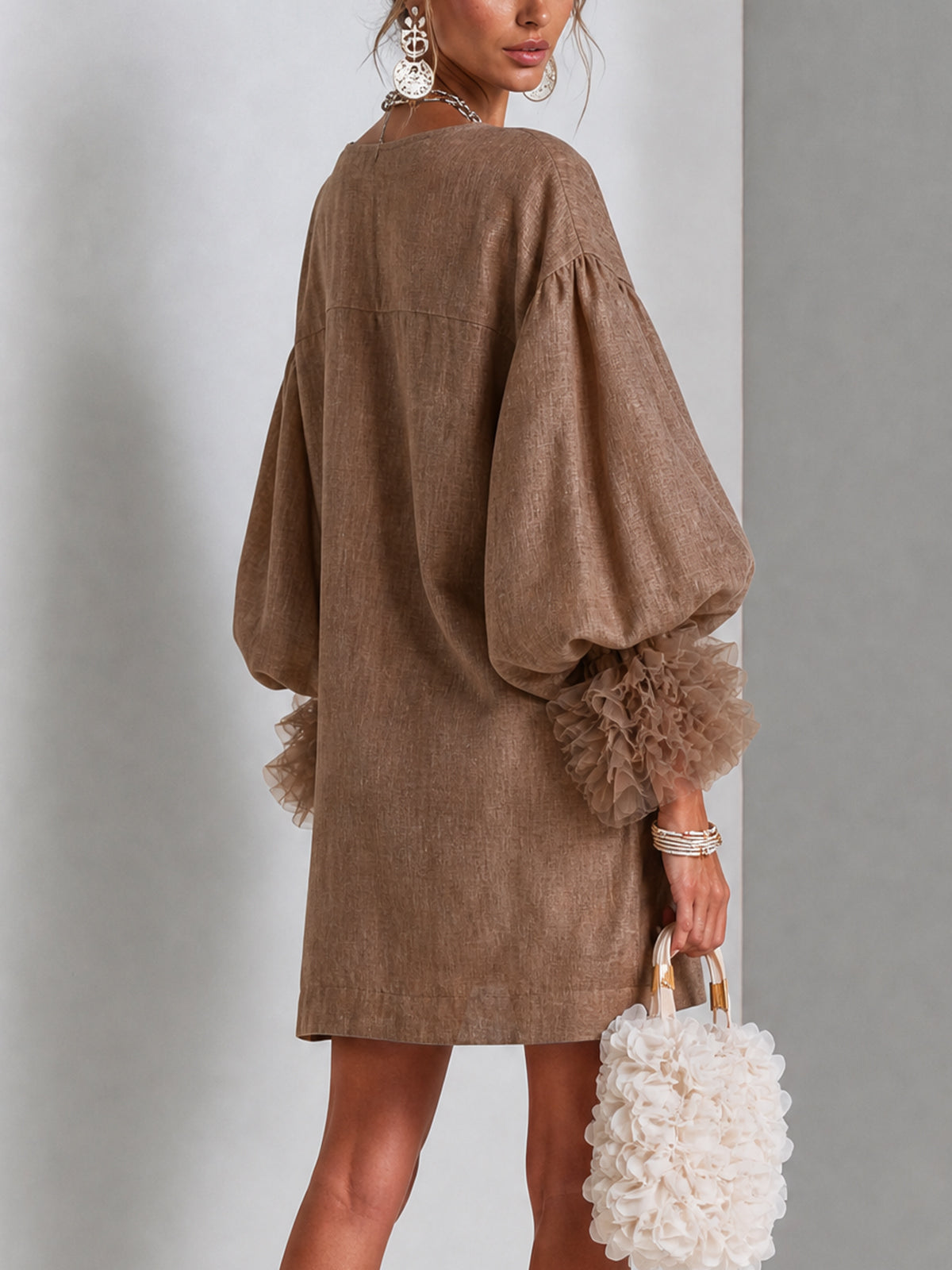 Brown midi dress with zip front, wide shoulders, and ruffle-trimmed balloon sleeves.