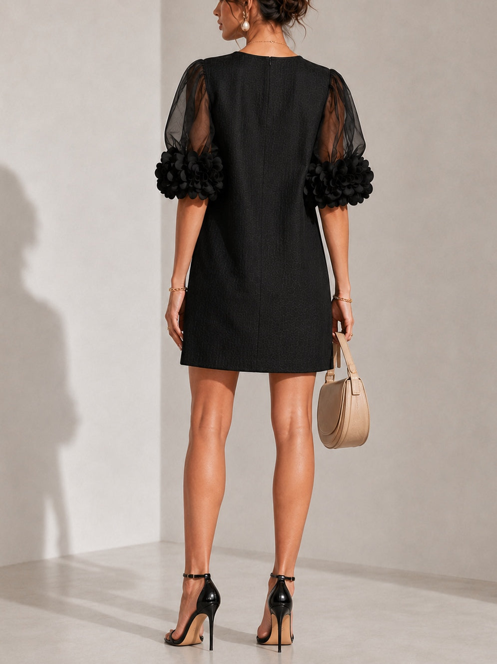 Black puff-sleeve midi dress, back view, sheer sleeves with rosette cuffs.