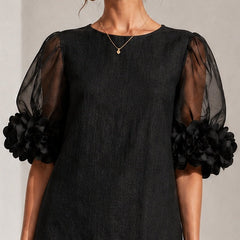 Black midi dress with sheer puff sleeves and rosette cuffs, crew neckline detail.