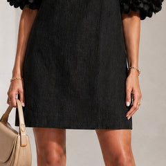 Black midi dress with sheer puff sleeves and rosette cuff embellishments, sleeved bodice.
