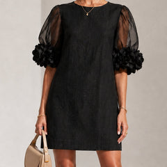 Black midi dress with sheer puff sleeves and rosette cuffs, crew neckline.