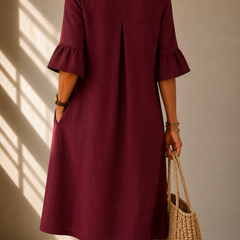 Burgundy button-front midi dress, back view with pleat at center and ruffle bell sleeves