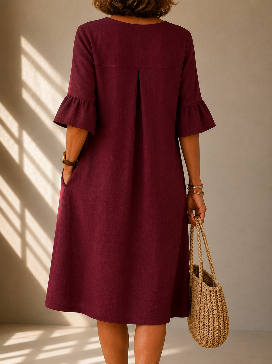 Burgundy button-front midi dress, back view with pleat at center and ruffle bell sleeves