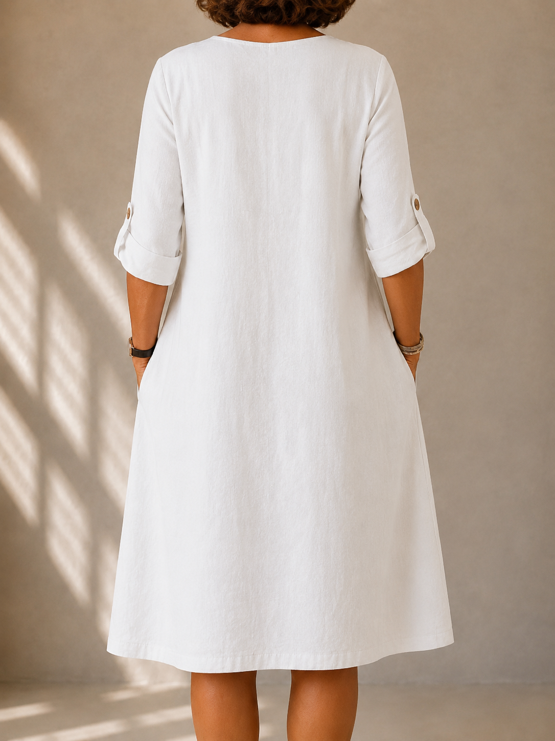 White midi dress back view with 3/4 sleeves and buttoned cuff details
