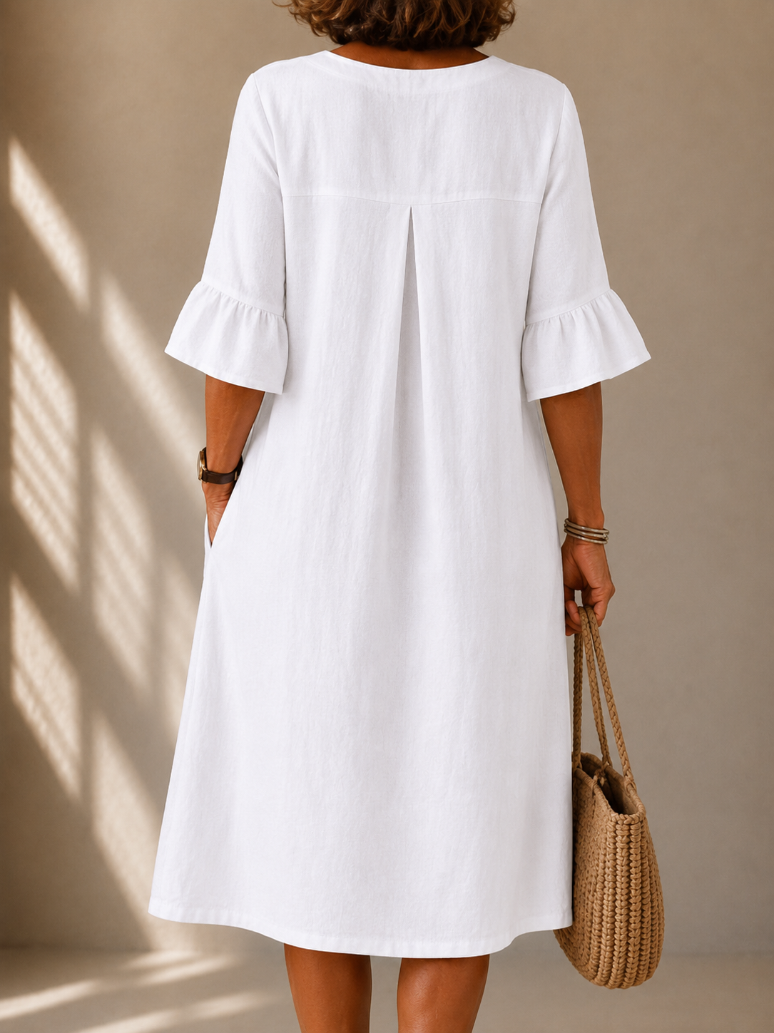 White button-back dress with gathered bell sleeves and central back seam