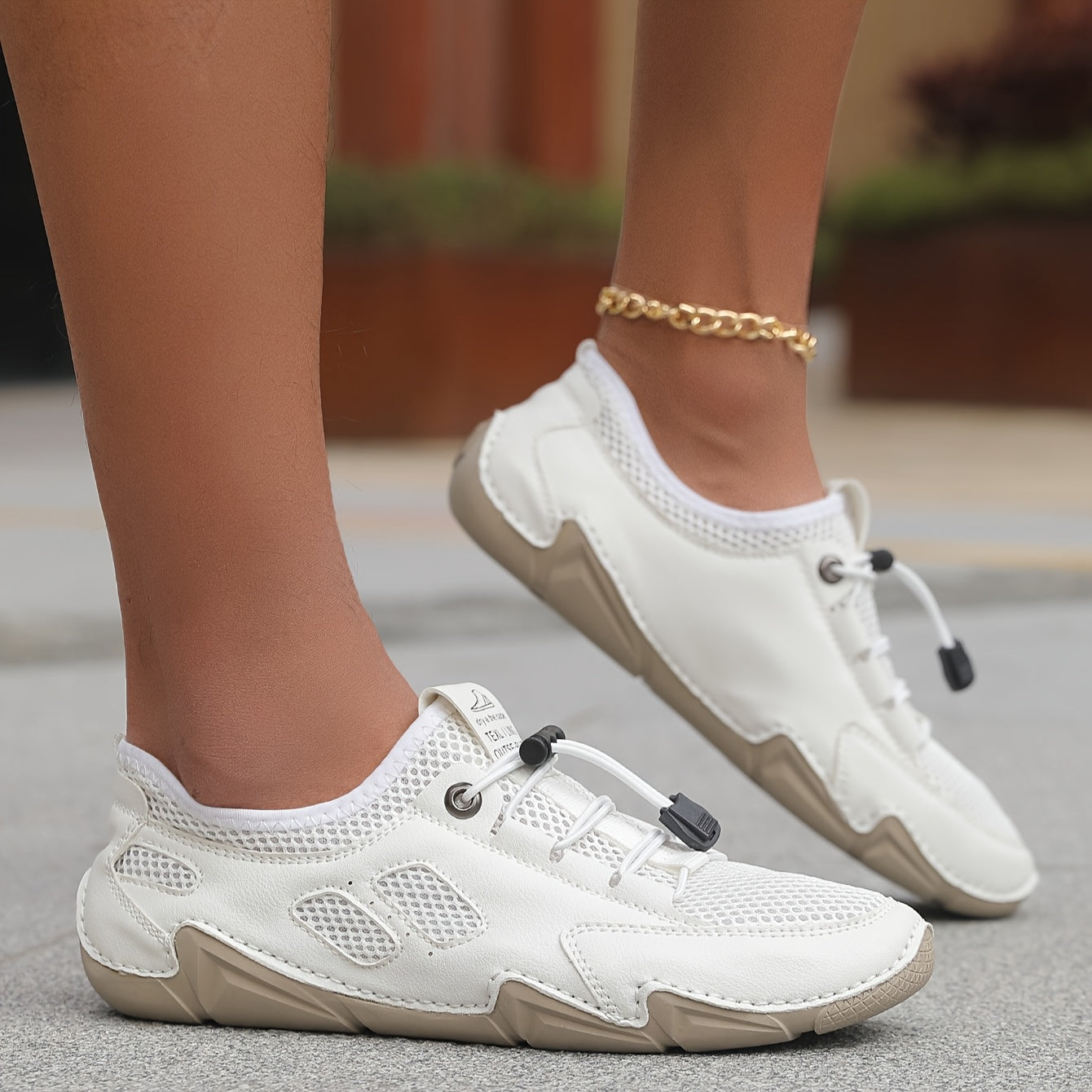 Scarpe da uomo bianche indossate, lacci neri e suola beige ammortizzata