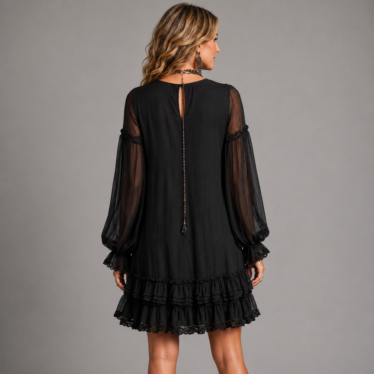 Black mini dress back view with sheer sleeves and open-back tie detail