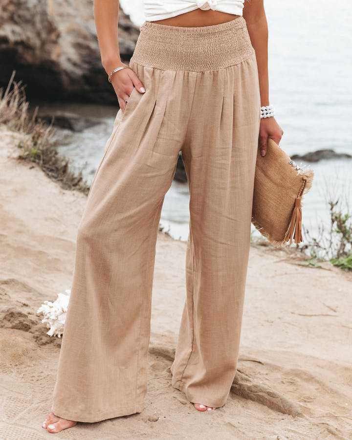Beige wide-leg trousers with shirred waistband, relaxed pleated front