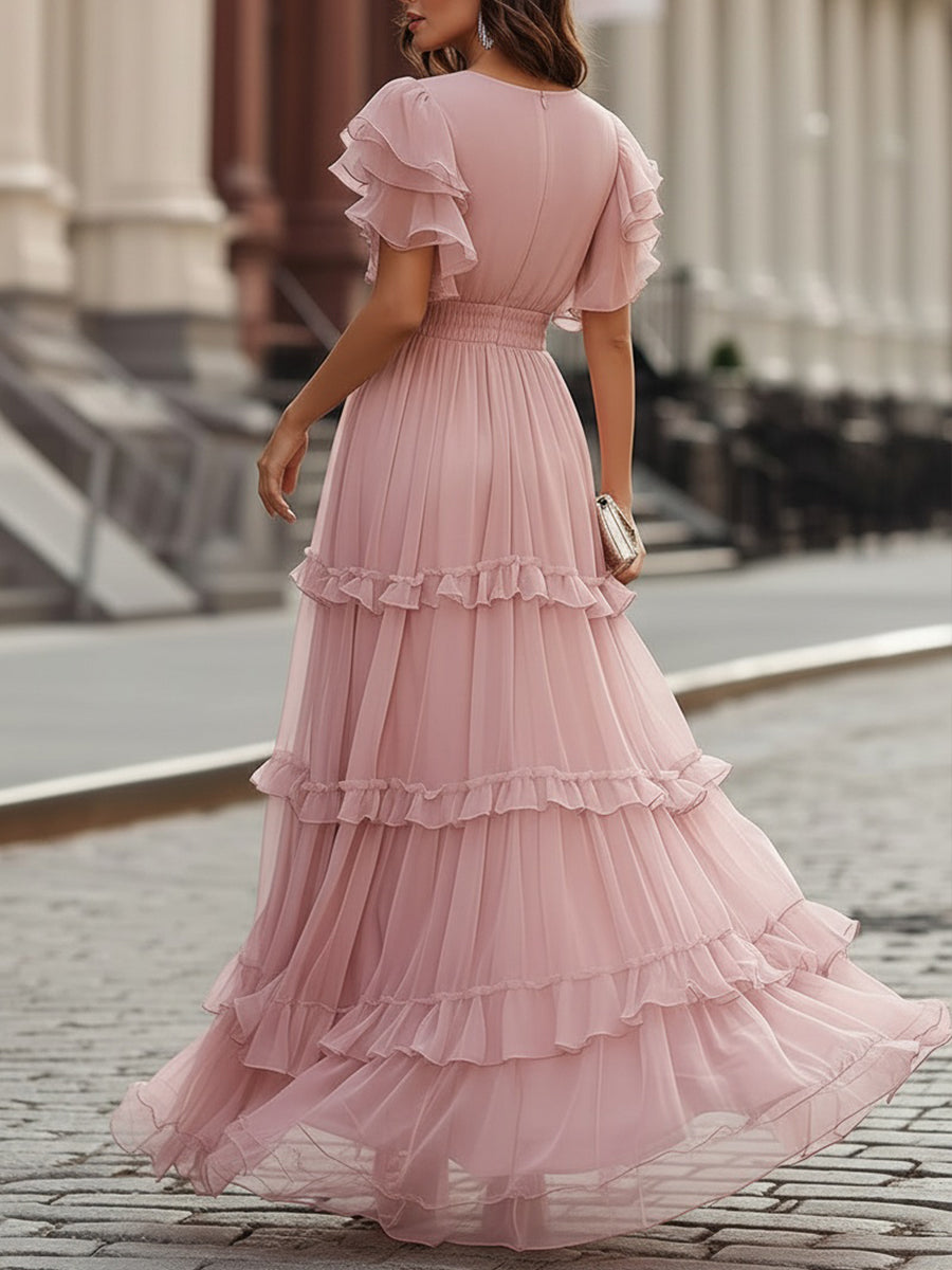 Pink tiered maxi dress with flutter sleeves and layered skirt, back neckline visible