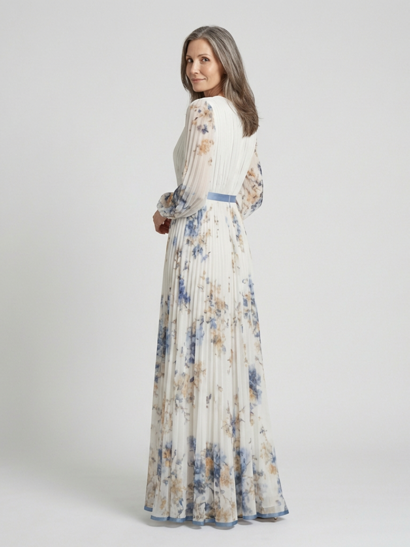 White floral long sleeve V-neck maxi dress, side view, pleated skirt and blue sash