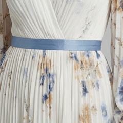 Pleated V-neck maxi dress close-up, blue waist sash over floral fabric