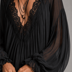 Black chiffon halter mini dress close-up: lace-edged V neckline and layered fabric