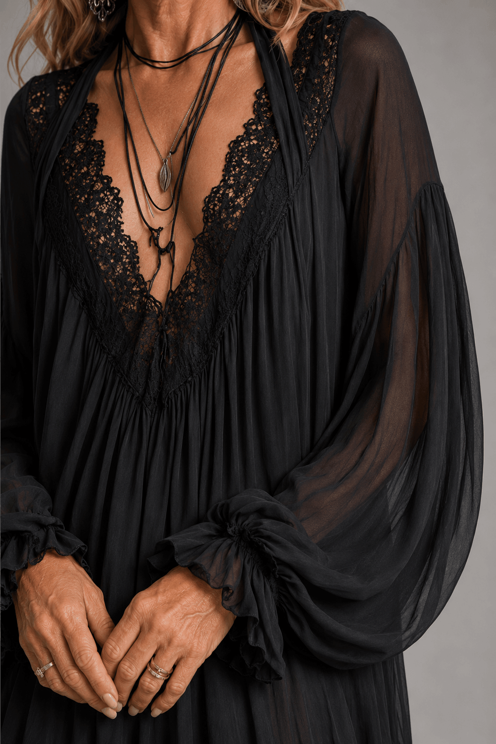 Black chiffon halter mini dress close-up: lace-edged V neckline and layered fabric