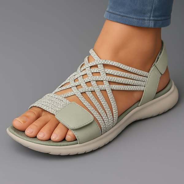 Sandali ortopedici verde chiaro con fascia intrecciata e cinturino con velcro, suola bianca.