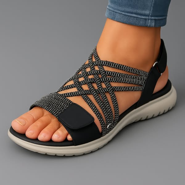 Sandali ortopedici neri con tomaia intrecciata e fascia con velcro, suola bianca.