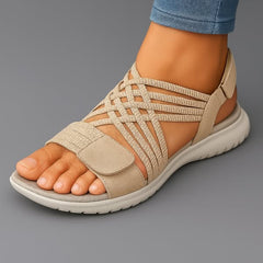 Sandali ortopedici con fascia intrecciata beige e cinturino con velcro, suola bianca.