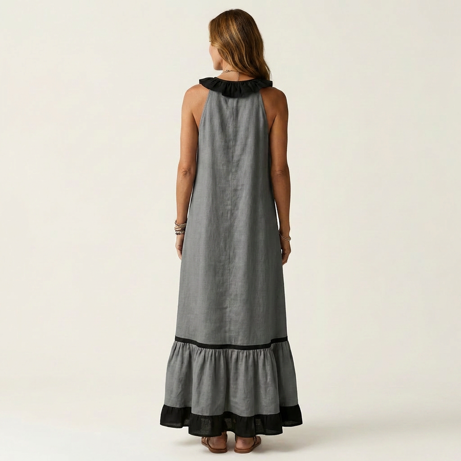 Sleeveless maxi dress in dark gray with black ruffle neck and contrast hem trim, back view