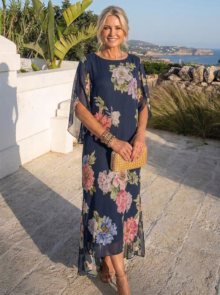 Abito maxi in chiffon blu scuro con grandi fiori rosa e lilla, maniche a mantella