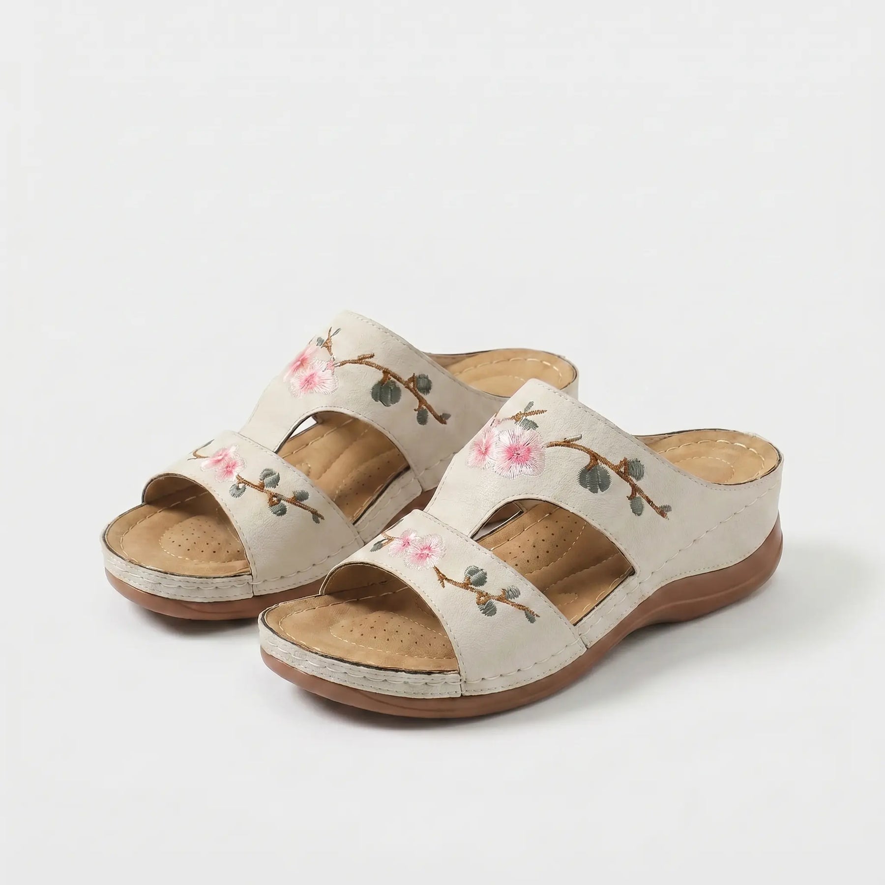 Sandali ortopedici beige con cinturini e ricami floreali rosa e steli verdi.