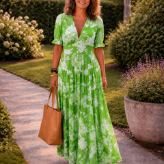 Abito lungo verde con scollo a V, maniche corte, stampa floreale e vita arricciata.