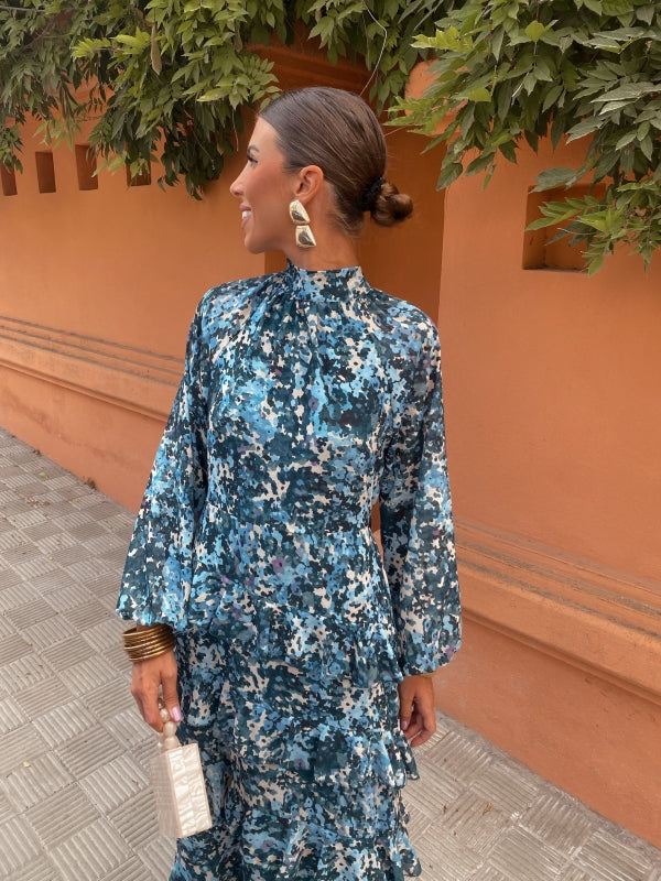 Blue floral midi dress with high neck, long sleeves, and tiered ruffle hem