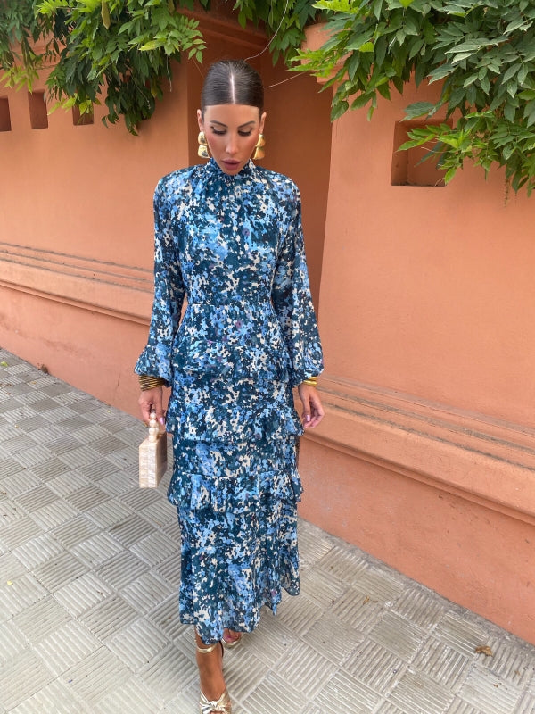 Blue floral midi dress with high neckline, long sleeves, and tiered ruffle hem