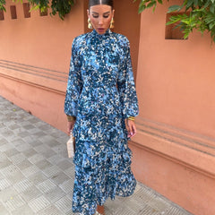 Blue floral midi dress with high neck, long sleeves, and layered tiered skirt