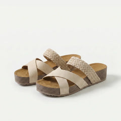 Sandali ortopedici con cinturini intrecciati beige e suola a zeppa.