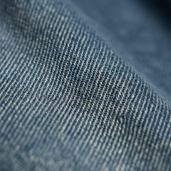 Washed blue denim fabric texture closeup with fine woven pattern