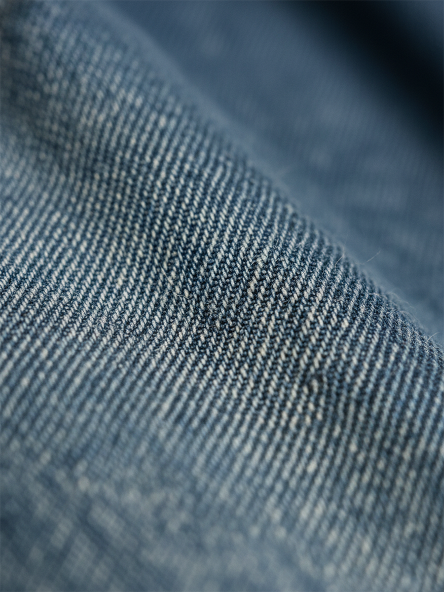 Washed blue denim fabric texture closeup with fine woven pattern