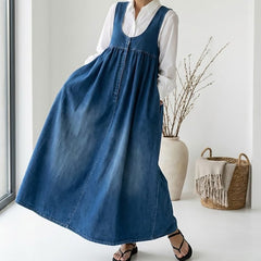 Dark blue denim maxi dress over white blouse, sleeveless with gathered skirt and buttons