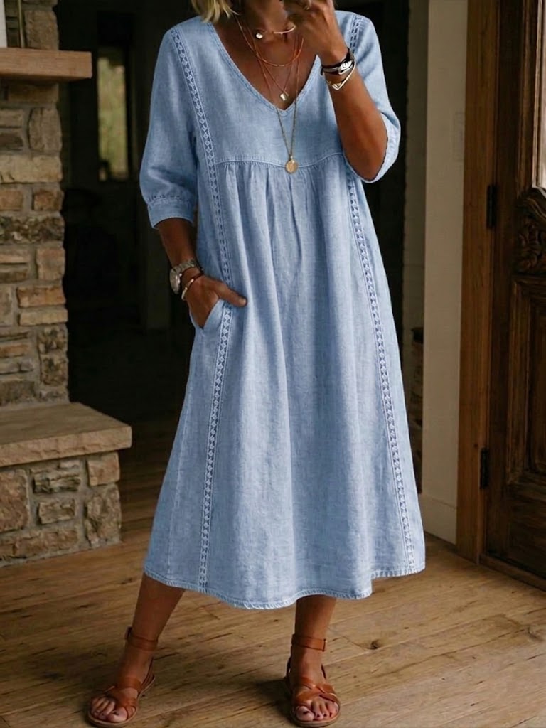Blue denim maxi dress with V-neck, gathered bodice, and 3/4 sleeves